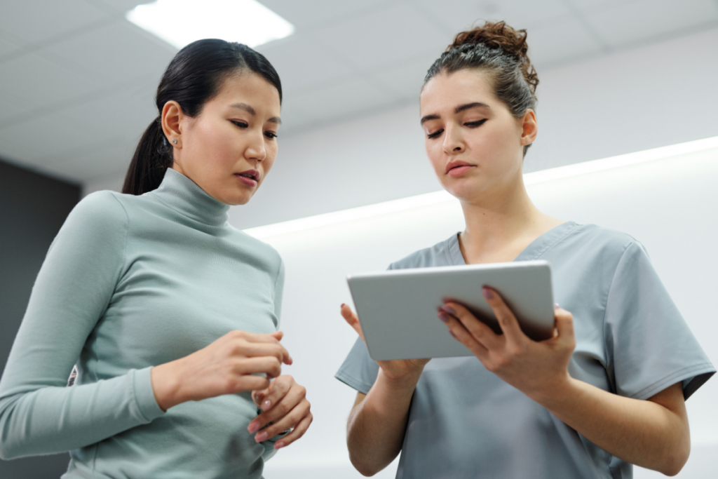 Healthcare professional showing patient information on a tablet during a clinic consultation