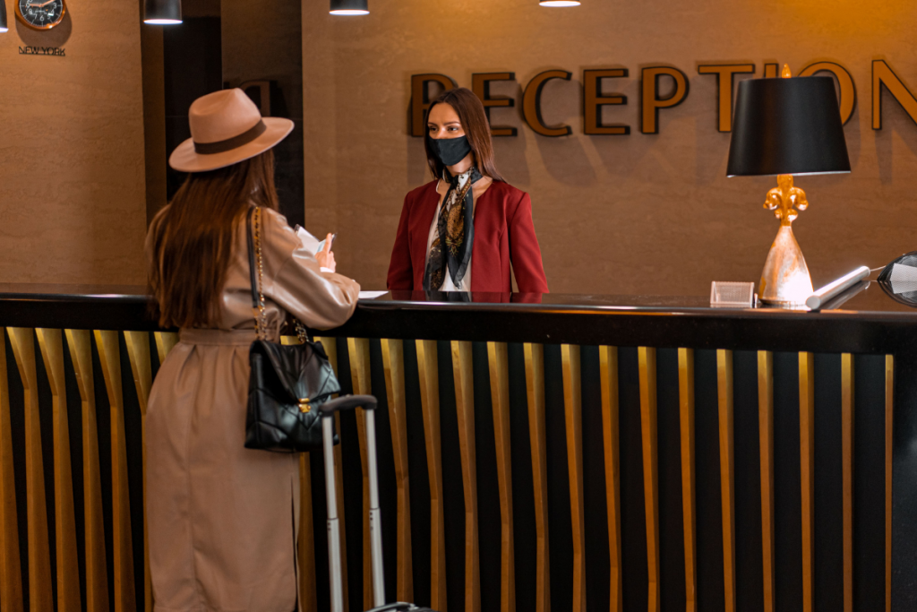 Hotel receptionist assisting a guest at a check-in kiosk