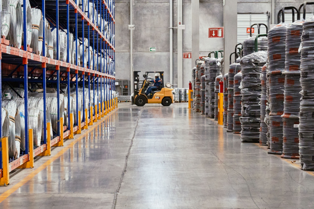 Warehouse worker operating a forklift among storage racks