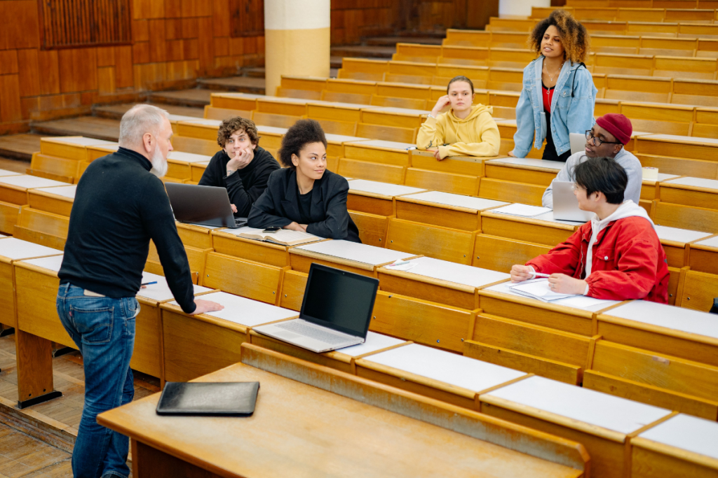 Teacher holding a laptop while managing classroom administration